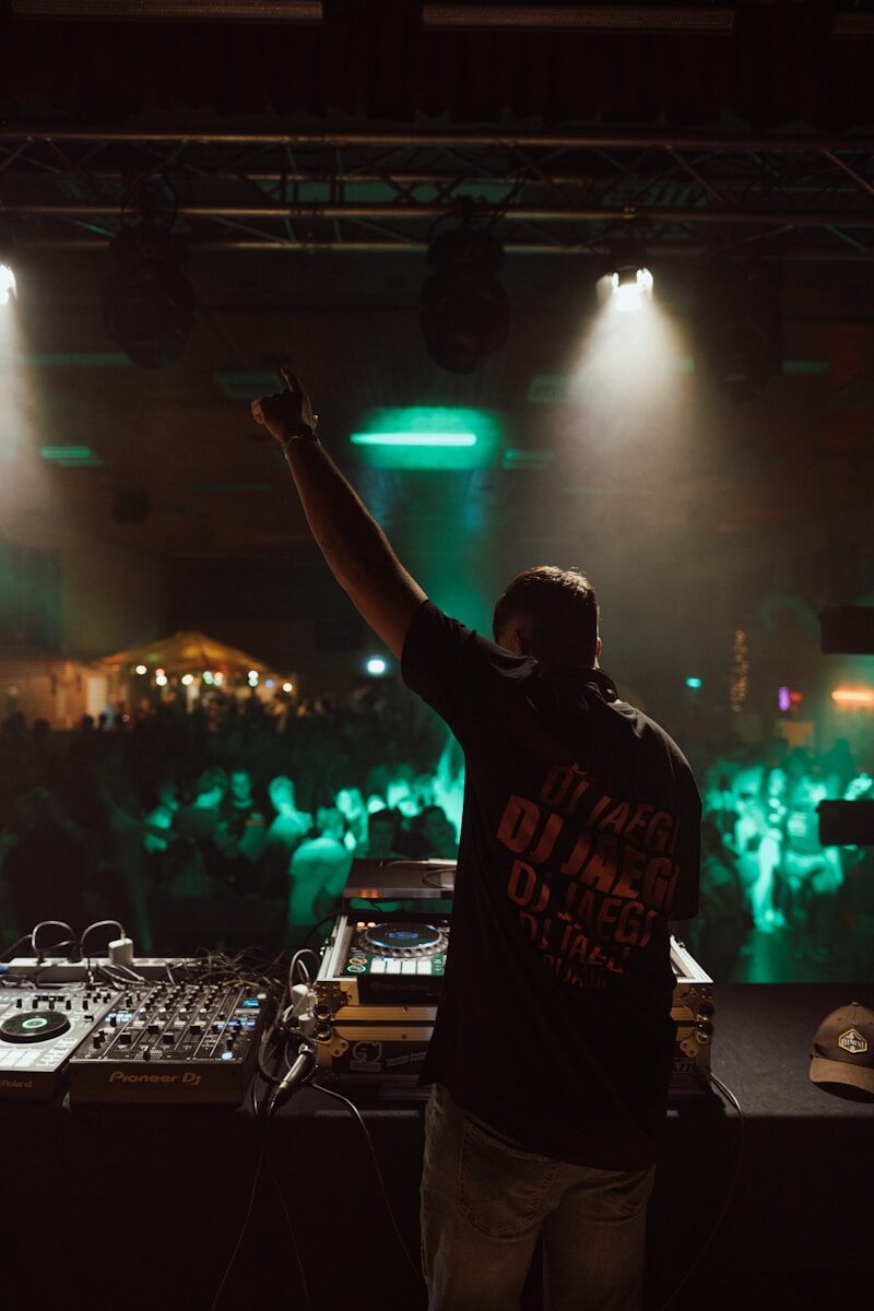 a man holding a microphone in front of a dj booth